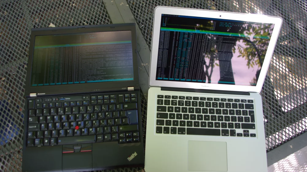 Lenovo ThinkPad and MacBook Air laptops side by side