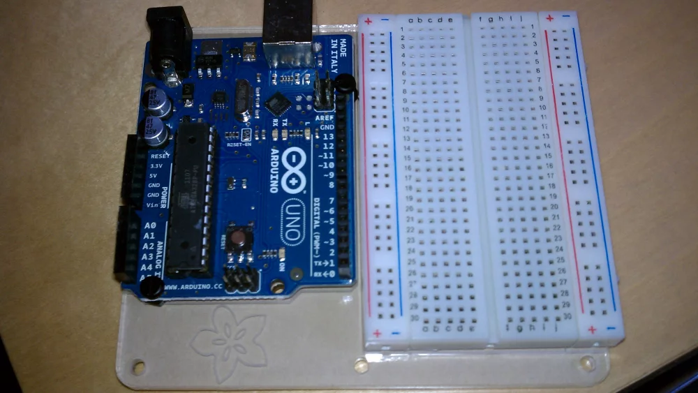 Arduino Uno board next to a solderless breadboard