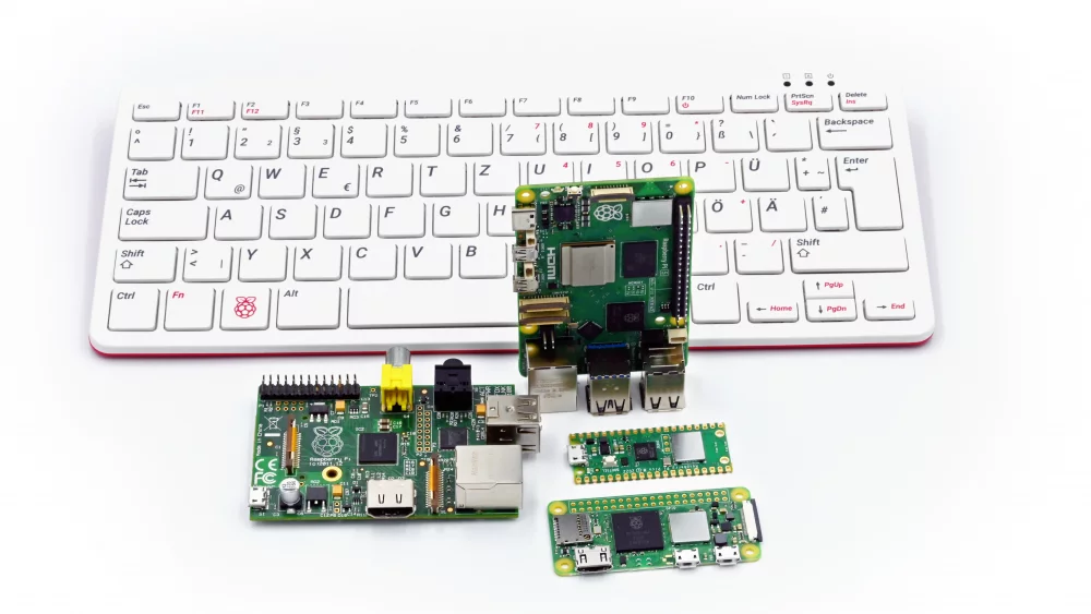 Raspberry Pi boards and a keyboard computer on a white desk